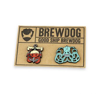 Two custom llustrated enamel badges on brown branded backing card for Brewdog